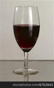 Poring red wine into a glass.Stop motion photography. By use of a sound activated switch, I am able to capture the moment that a glass breaks. Pictured here a glass of red wine.