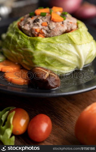 Pork cabbage soup with carrots, chopped green onions, cucumber in a wooden plate on a wooden plate.