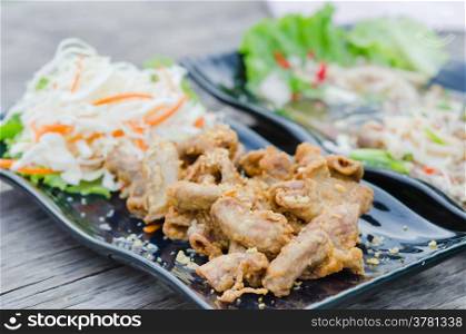 pork chitterlings fried . pork chitterlings fried served with fresh vegetable on dish