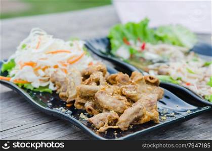 pork chitterlings fried . pork chitterlings fried served with fresh vegetable on dish