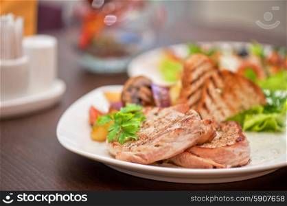 Pork chop. Pork chop with vegetable at plate