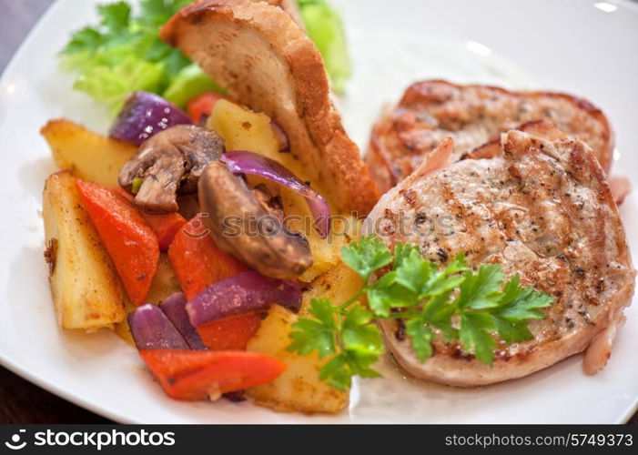 Pork chop with vegetable at plate. Pork chop