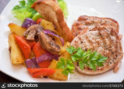 Pork chop with vegetable at plate. Pork chop