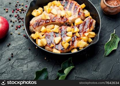 Pork entrecote cooked with aromatic autumn apples.Appetizing meat with caramelized apples.. Steak with caramelized apple in pan