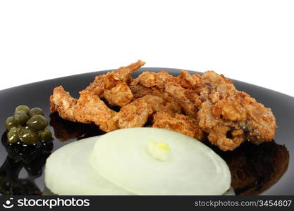 Pork greaves on black plate isolated on white