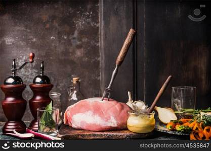 Pork Ham meat with Honey Mustard Glaze and ingredients, preparation on aged kitchen table at dark rustic wooden background, side view, place for text