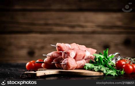 Pork kebab raw on a cutting board. On a wooden background. High quality photo. Pork kebab raw on a cutting board.
