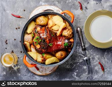 Pork knuckle on wooden surface.Roasted pork knuckle with potatoes. Pork knuckle with fried sauerkraut