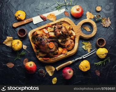 Pork knuckle or shank grilled with apples on cutting board. Roasted meat with autumn fruits