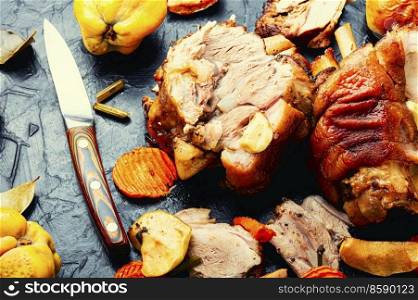 Pork knuckle or shank stewed in dark beer with quince and apples.. Roasted meat with autumn fruits