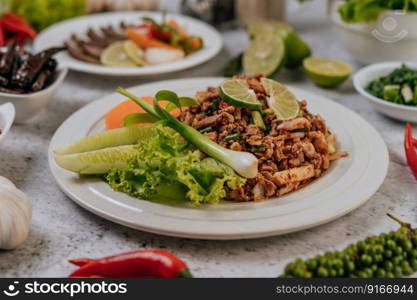 Pork Larb with carrot, cucumber, lime, spring onion, chili, freshly ground pepper, and lettuce.