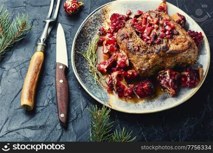 Pork loin in a fruity marinade. Fried meat with pomegranate. Christmas food. Pork loin in pomegranate marinade.
