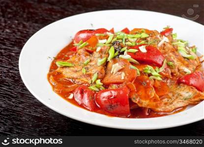 pork meat with tomato, pepper, prunes, garlic and green onion