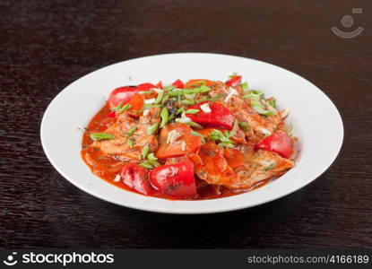 pork meat with tomato, pepper, prunes, garlic and green onion