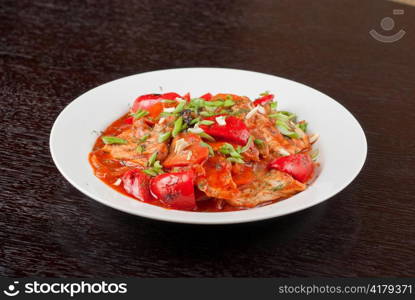 pork meat with tomato, pepper, prunes, garlic and green onion