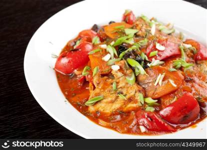 pork meat with tomato, pepper, prunes, garlic and green onion