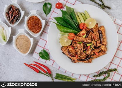 Pork Nam Tok with fried chili, tomato, lime, cucumber, and fresh pepper. Thai food.