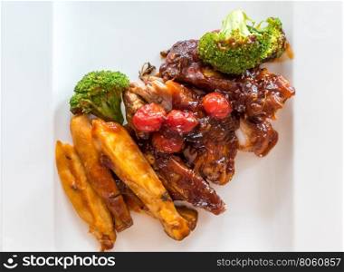Pork Rib Grilled and Fried Potato Wedges on White Plate with Sauce and Veggies, Gourmet cuisine.
