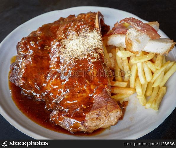 pork rib steak serve on plate / barbecue pork roast french fries bacon and spicy sauce - grill spare ribs honey dip