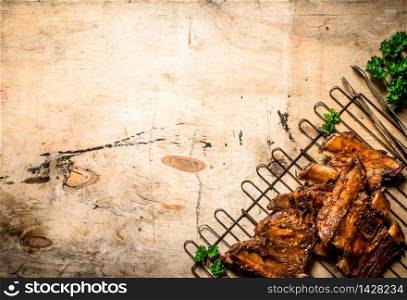 Pork ribs grilled on the grill. On wooden background.. Pork ribs grilled on the grill.