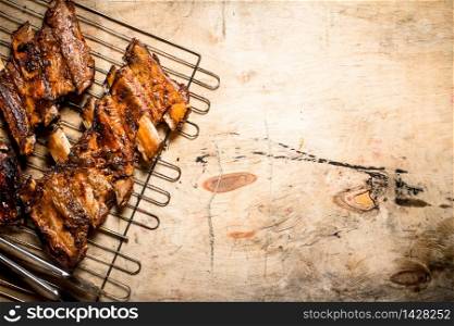 Pork ribs grilled on the grill. On wooden background.. Pork ribs grilled on the grill.