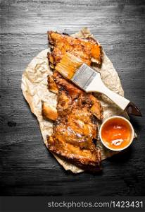 Pork ribs grilled with a spicy sauce and a brush. On the black chalk Board. Pork ribs grilled