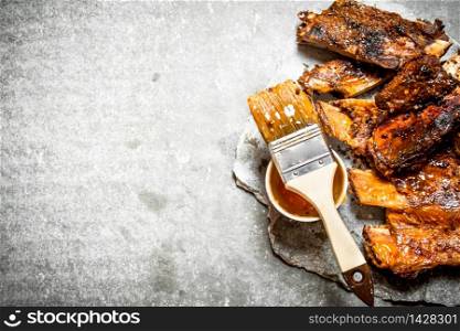 Pork ribs grilled with tomato sauce. On a stone background.. Pork ribs grilled with tomato sauce.