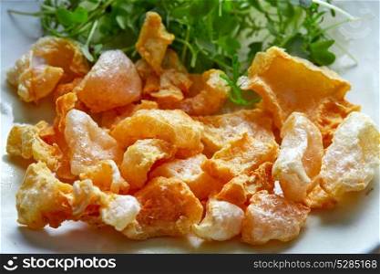 Pork rinds appetizer on white dish and salad