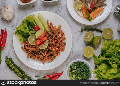 Pork Skin Larb with carrot, cucumber, lime, spring onion, chili, freshly ground pepper, and lettuce.