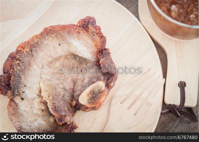 Pork steak on wooden plate, stock photo