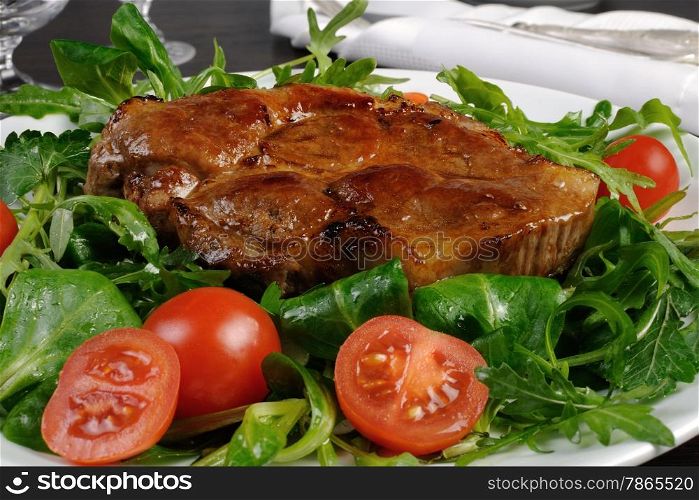 Pork steak with ketchup, arugula, cherry tomatoes