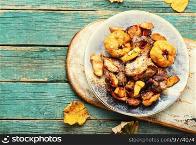 Pork stew with quince on an old wooden table. Autumn recipe. Pork cooked with autumn quince.