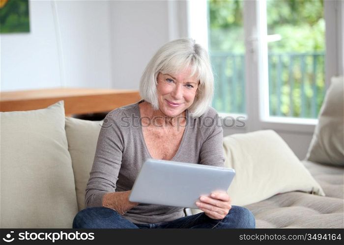 Porrtait of senior woman using electronic tablet at home