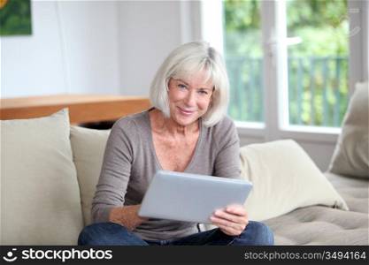 Porrtait of senior woman using electronic tablet at home