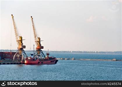 Port cranes in port. In the background is the coastline of the city. Odessa, Ukraine.