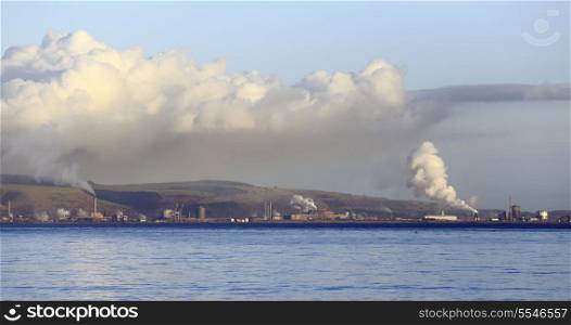 Port Talbot, South Wales, seen from the other side of Swansea Bay, with the industrial chimneys discharging into the winter sky under a blanket of what appears to be photochemical smog