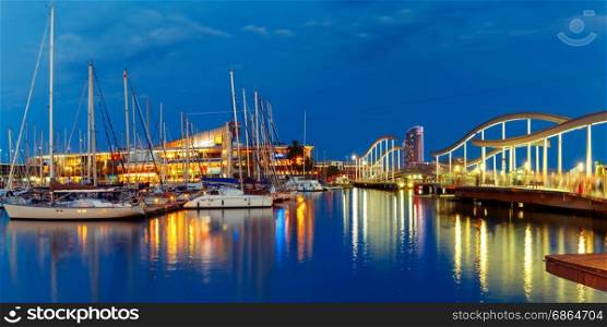 Port Vell and Rambla de Mar, Barcelona, Spain. Panorama with Port Vell marina and wavy wooden walkway known as the Rambla de Mar at night in Barcelona, Catalonia, Spain.