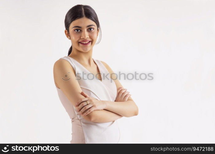 Portait of a young woman standing with hands folded.