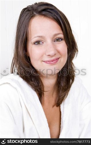 portait of a young woman, wearing a terry towelling bathrobe, smiling at the camera