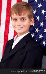 Portait of Caucasian boy with American flag in background.