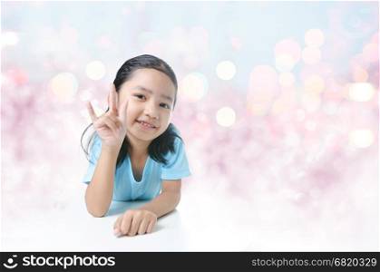 Portait of smile Asian little girl showing sign of love hand on bokeh background