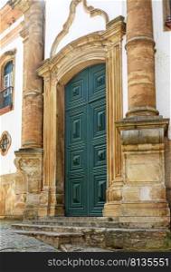 Portal of a historic baroque church in the city of Ouro Preto in wood framed by a stone arch.. Portal of a historic baroque church in the city of Ouro Preto 