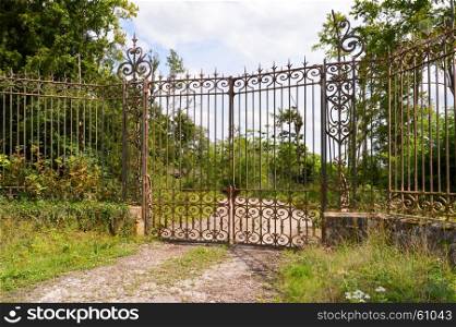 Portal of entrance of a castle . Portal of entrance of a castle with old forged gates in a forest of the Meuse in France