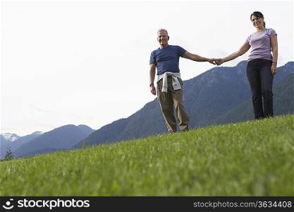 Portarit of couple holding hands, mountain range in background