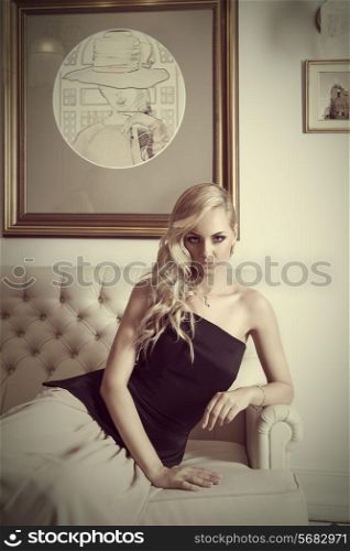 portarit of young and pretty woman , with hair style , sitting on white sofa looking in camera