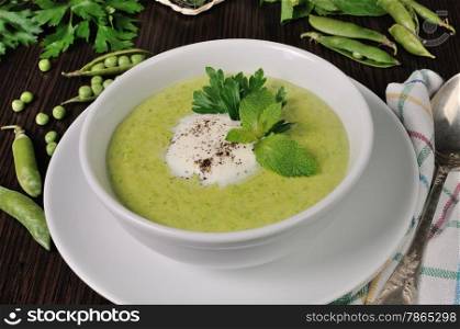 Portion cream soup with green peas with mint cream