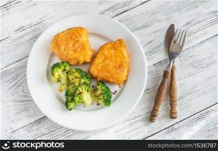 Portion of battered fish with steamed broccoli