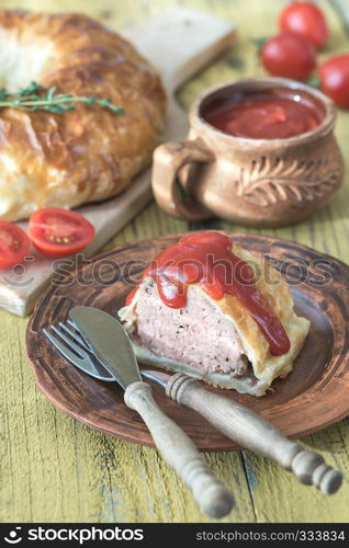 Portion of beef Wellington with tomato sauce