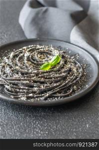Portion of Cacio e pepe pasta with wheat germ and black squid ink