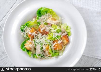 Portion of Caesar salad in the white plate